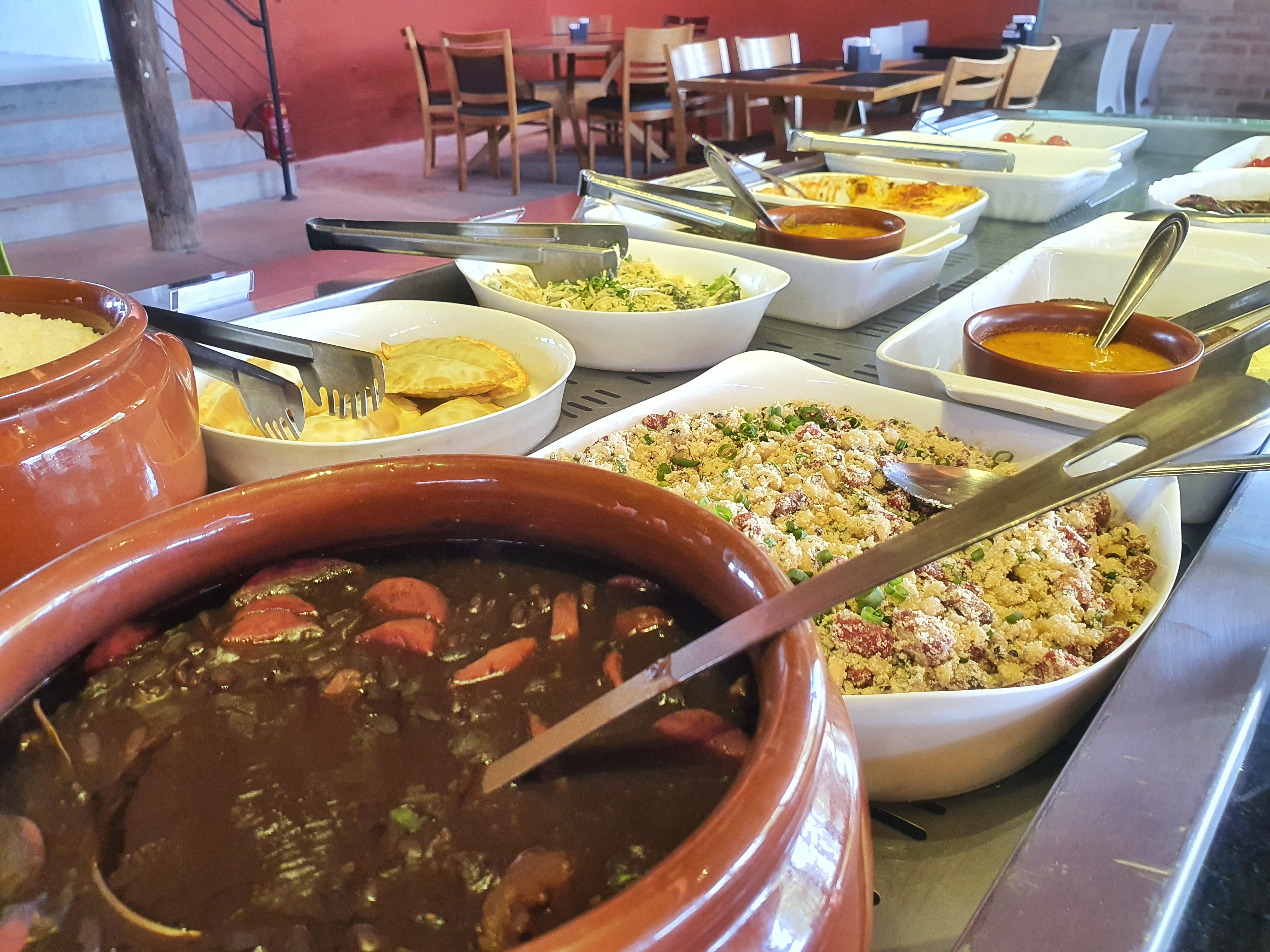 Panelas de barro e preparações do buffet quente do Cibi Sana